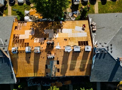 Florida Sky Roofing crew mid-replacement on a Central Florida home, decking exposed and new underlayment going down